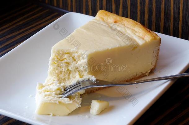 平原烘烤制作的奶酪蛋糕和蛋糕向餐叉向白色的陶器的盘子.