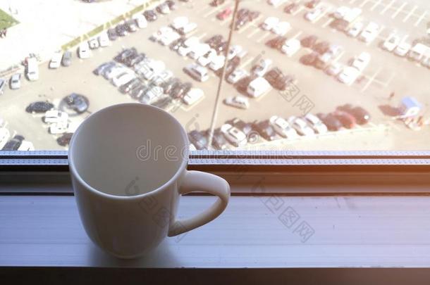白色的咖啡豆杯子向铝窗窗台.
