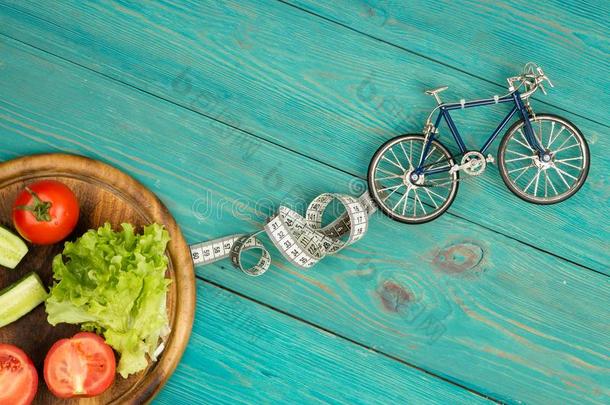 自行车模型,新鲜的蔬菜和厘米带子向蓝色木材