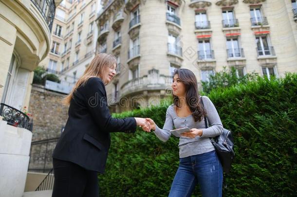 美丽的女孩讲话和外国的中国人学生遵守tablet药片