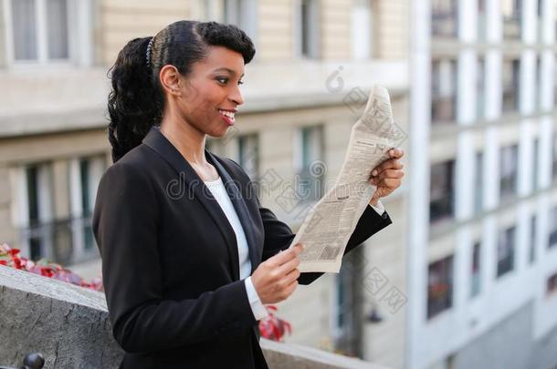 非洲式发型美国人女孩阅读报纸和关在上面关于面容.