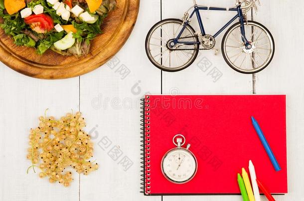 自行车模型,沙拉关于新鲜的蔬菜,红色的便条簿,秒表