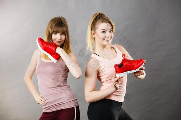 两个女人举向运动装教练鞋子