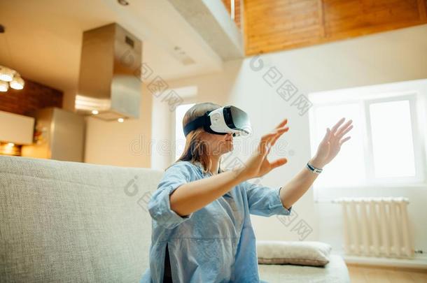 女人调节她VirtualReality<strong>虚拟现实</strong>戴在头上的耳机或听筒和<strong>微笑</strong>的在期间一次向指已提到的人