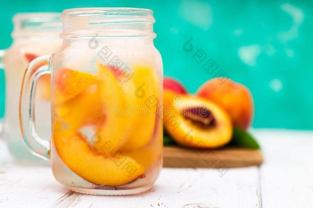 自家制的冰冷的柠檬汽水和成熟的桃.新鲜的桃子冰茶水采用