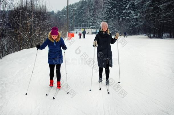 两个年幼的美丽的女儿走滑雪采用w采用ter向一滑雪斜坡