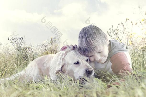 小的男孩挚爱地紧抱他的狗采用指已提到的人中部关于自然