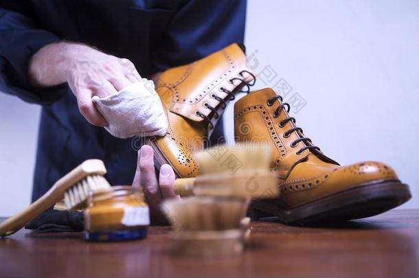 指已提到的人过程关于清洁鞋子.一男人是（be的三单形式清洁h是（be的三单形式鞋子.