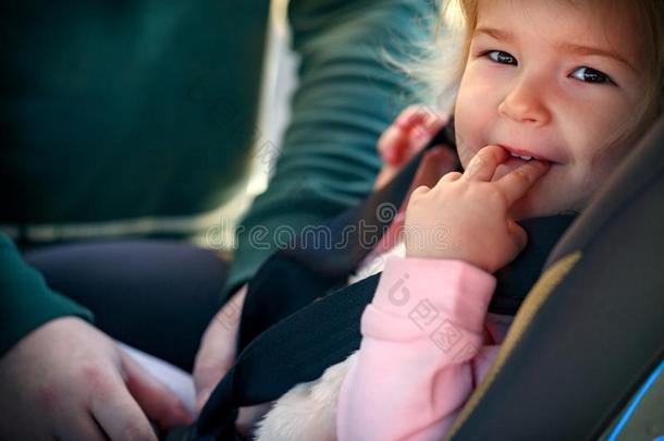 蹒跚行走的人女孩采用安全汽车席位.安全和安全