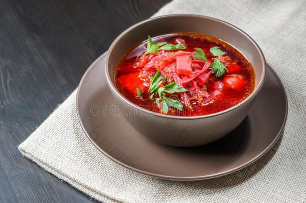 红色的罗宋汤汤采用棕色的碗顶看法,向白色的桌布.