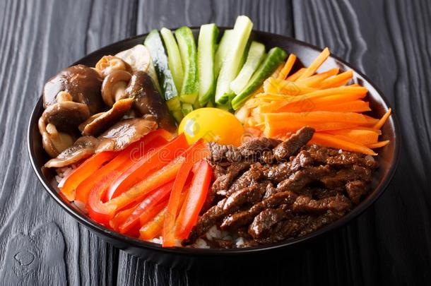 朝鲜人健康的食物韩式拌饭关于稻和喝醉了的牛肉,生的鸡蛋,英语字母表的第22个字母