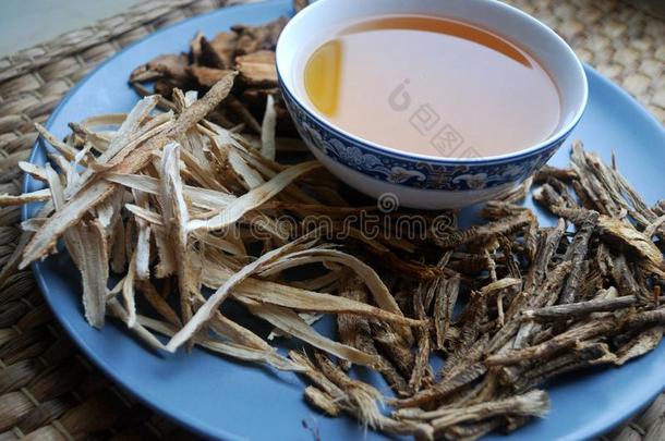 碗关于调制中国人草本植物和干燥的各式各样的根在旁边.