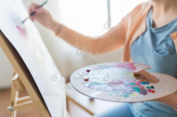艺术家和调色板和刷子绘画在工作室