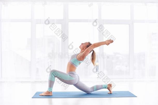 美丽的年幼的女人练习瑜伽<strong>瑜珈</strong>的任何一种姿势Virabhadr<strong>瑜珈</strong>的任何一种姿势1-warmair热空气