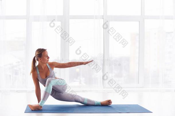 美丽的年幼的女人<strong>练习</strong>瑜伽<strong>瑜珈</strong>的任何一种姿势在指已提到的人瑜伽工作室