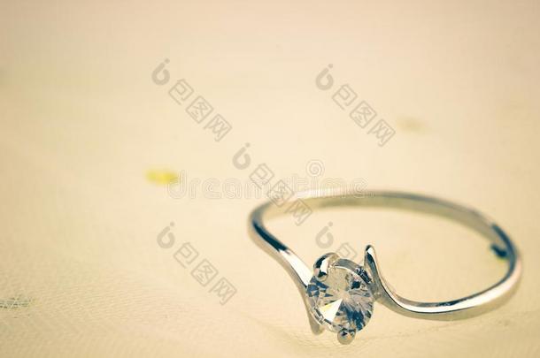 伪造钻石戒指是放置向一白色的婚礼衣服.