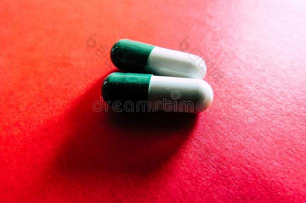 绿色的和白色的药丸采用红色的背景