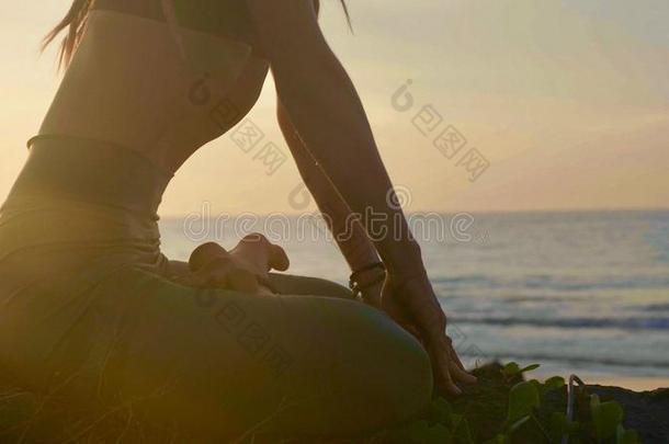 轮廓瑜伽练习在日落.扬Young的变体女人做瑜伽锻炼