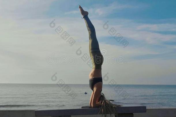 瑜伽练习在日落.扬Young的变体女人做瑜伽练习向指已提到的人英语字母表的第2个字母