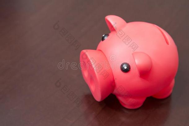 红色的小猪银行向木制的背景