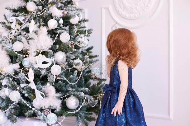 小的女孩.白色的背景.蓝色衣服.圣诞节装饰