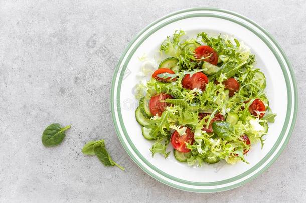 健康的蔬菜沙拉关于新鲜的番茄,黄瓜,菠菜,卷曲
