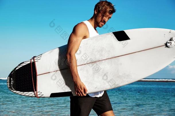 模型冲浪运动员使人疲乏的偶然的衣服出行和冲浪板向蓝色
