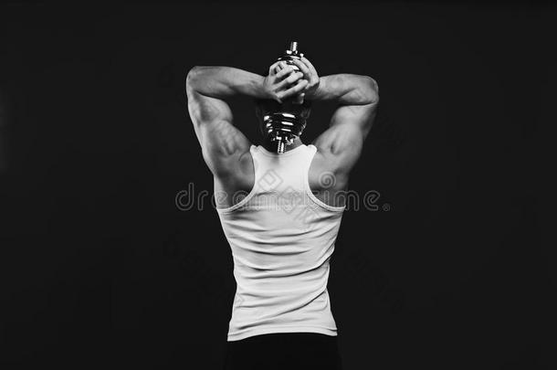 强的运动员的男人和哑铃展示会肌肉的身体