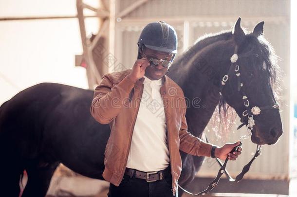 非洲的男人使人疲乏的太阳镜在近处黑的马采用飞机库