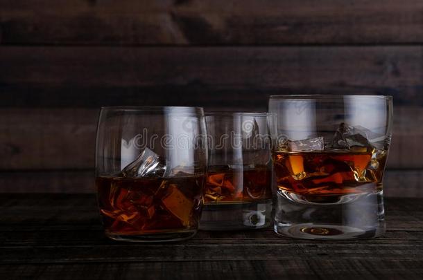 眼镜关于威士忌酒和冰立方形的东西向木制的表