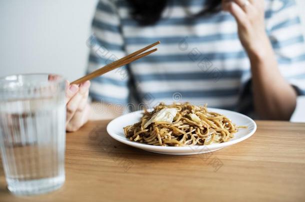 亚洲人女人吃喝醉了的面条向指已提到的人表