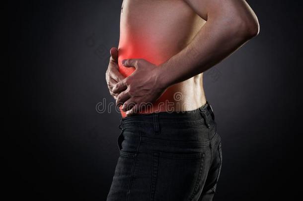 男人和腹部的痛苦,胃疼痛向黑的背景