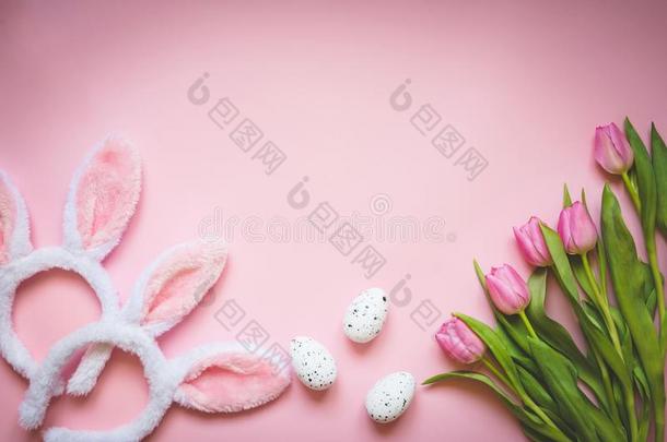 顶看法关于复活节卵,粉红色的郁金香和两个白色的松软的兔子