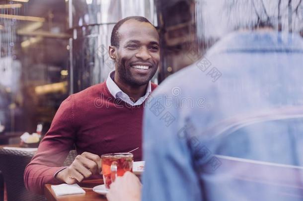 快乐的愉快的男人吃在咖啡馆和朋友