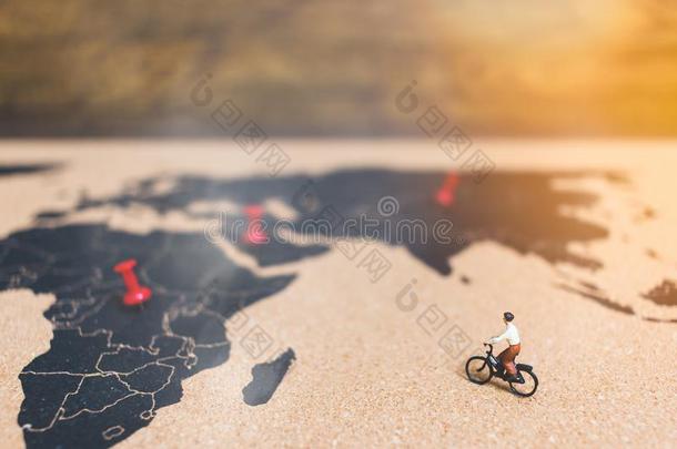 小型的人旅行支票骑马自行车向世界地图,旅行家