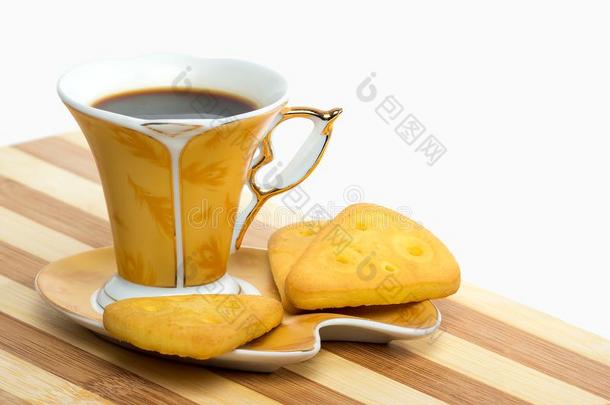 一金色的杯子关于浓咖啡看台向一s一ucer和一饼干向一wickets三柱门