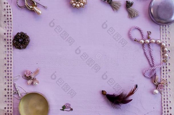 不同的珠宝首饰和蕾丝框架粉红色的背景