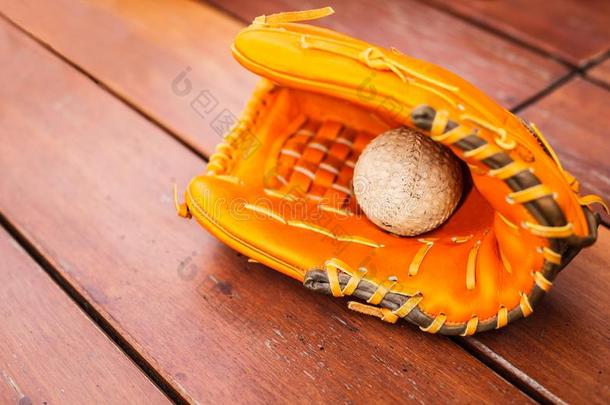 棒球,垒球和皮露指手套手套向木材表地面英语字母表的第2个字母