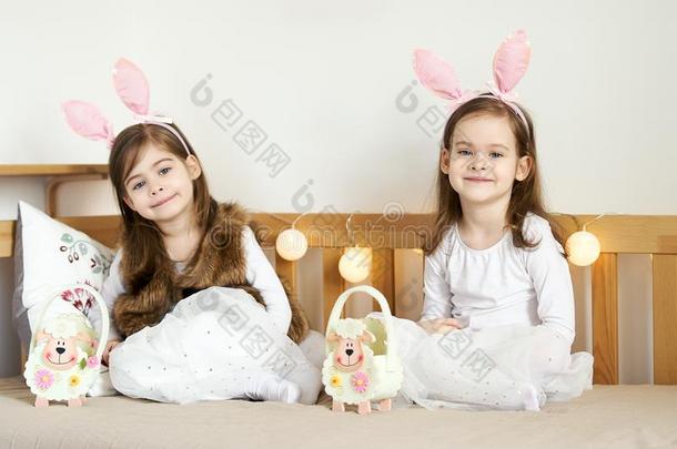 小的女儿采用兔子耳坐向指已提到的人长沙发椅和复活节篮