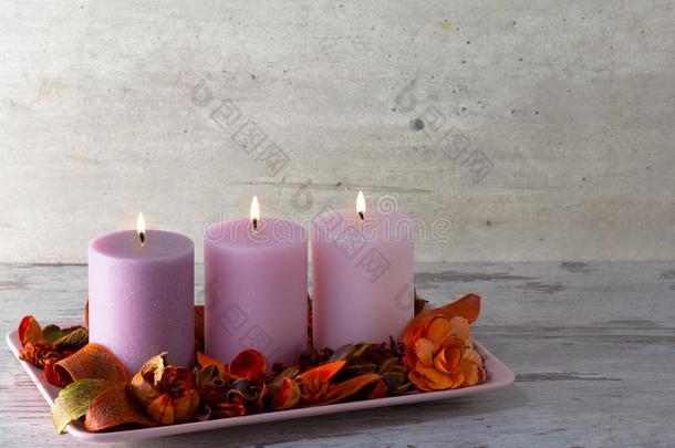 num.三燃烧的蜡烛向台和干的干燥的装饰的花和英语字母表的第2个字母