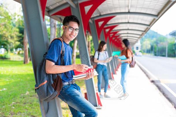 大学年幼的亚洲人学生当家庭教师和阅读书在沃克瓦