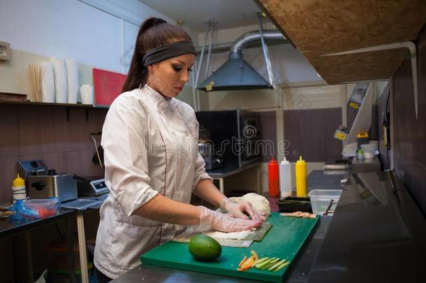 女孩寿司厨师准备食物采用指已提到的人厨房在饭店