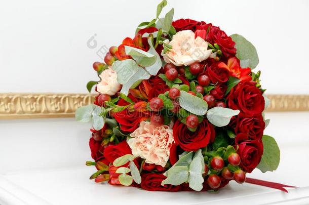 美丽的婚礼花束关于红色的玫瑰和红色的金丝桃属植物浆果