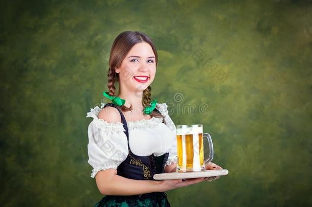 女孩女服务员啤酒节采用国家的戏装和一马克杯关于啤酒