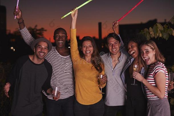 成熟的朋友波浪状的发光棒在屋顶社交聚会采用反击球