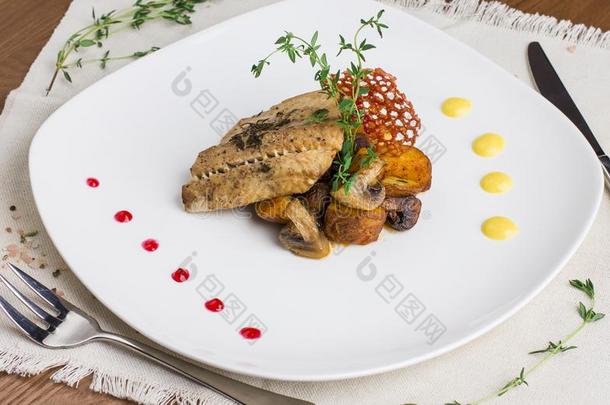 烘烤制作的鱼和马铃薯和蘑菇向白色的盘子