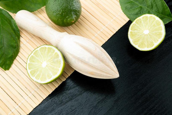 健康的食物和维生素:一木制的榨汁器和绿色的新鲜的酸橙图片