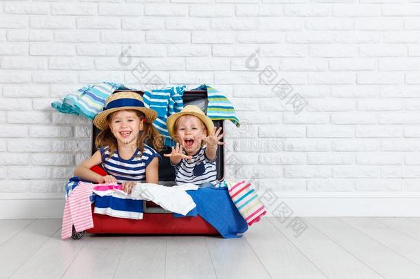 幸福的笑的孩子们和手提箱出行向一旅游