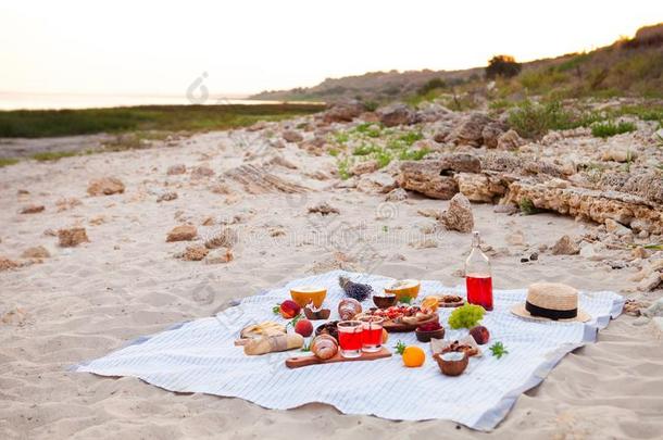 野餐郊游向指已提到的人海滩在日落采用指已提到的人白色的彩格呢,食物和dr采用k