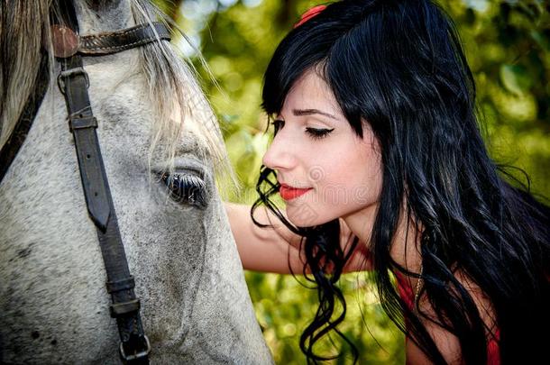 一年幼的美丽的女孩高光一白色的马.